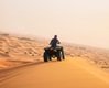 Man riding black atv on brown sand in merzouga desert